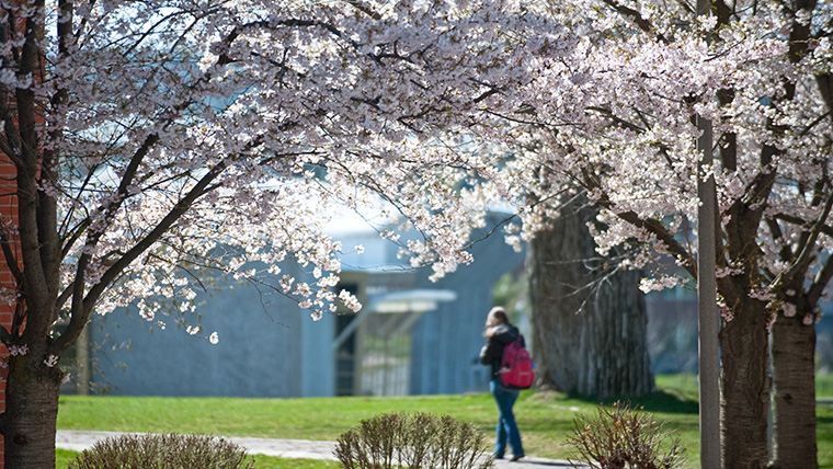 Student walking on campus near Rudolf Fitness Center
