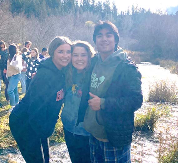 Three students alongside a river.