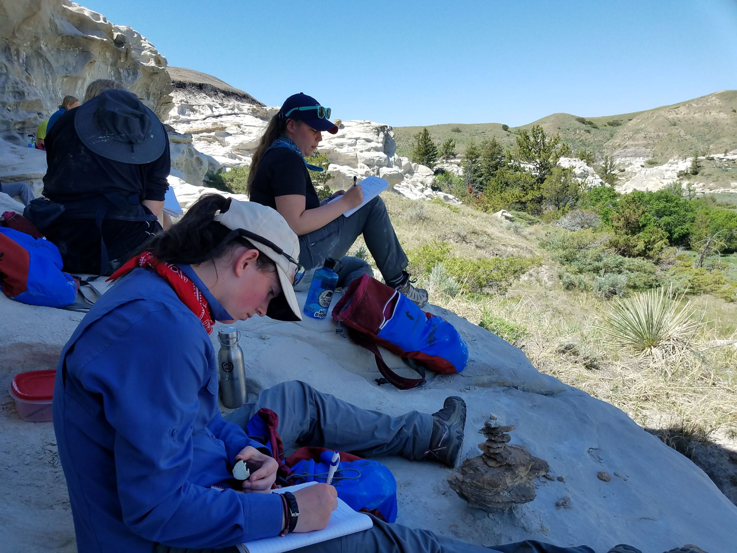 students journaling outdoors