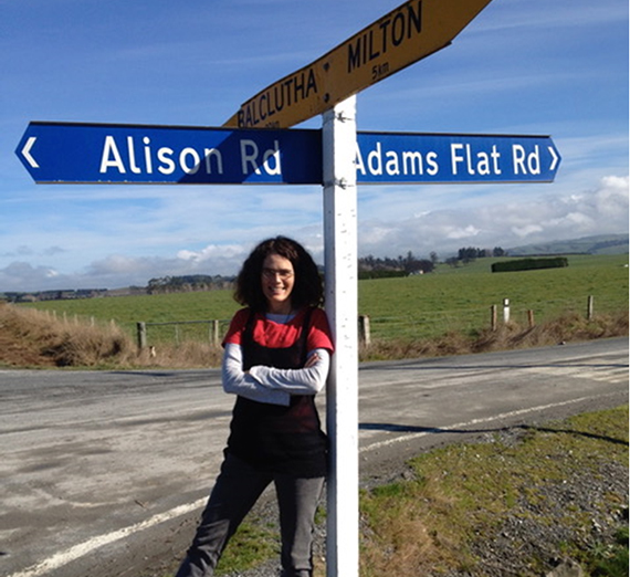 Alison McCulloch, Gonzaga Philosophy graduate, stands in front of a street sign bearing her first name. 