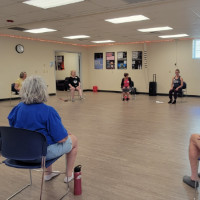 Group class leader and a student seated in a circle.