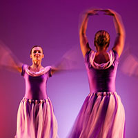 Two dancers face opposite directions.