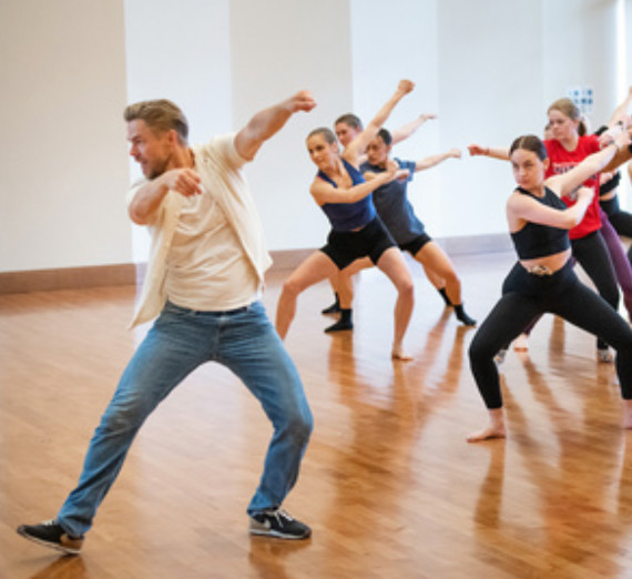 Derek Hough works with students
