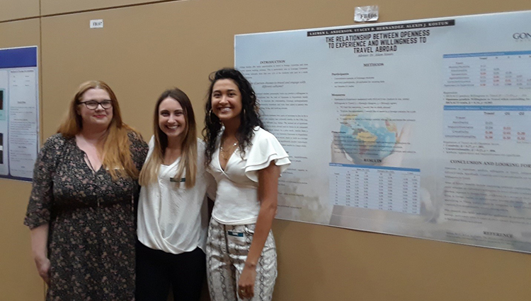 Students standing with a research poster.