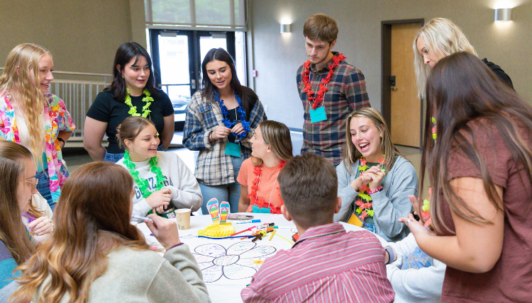 Counselor Education students gather at a table to discuss an activity