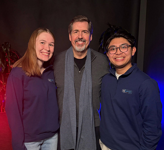 Two Zagluencer students stand on either side of Gonzaga University President Thayne McCulloh.