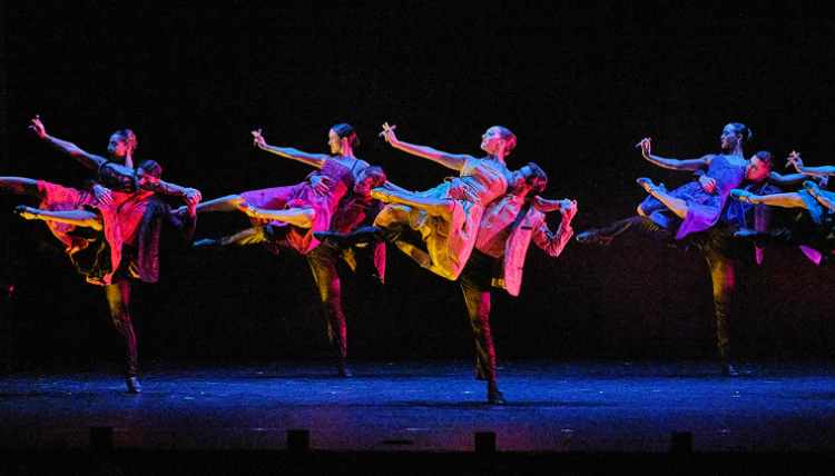Dancers performing in unison on stage.