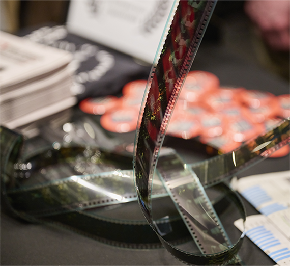 Film from a film reel piling up on a surface.
