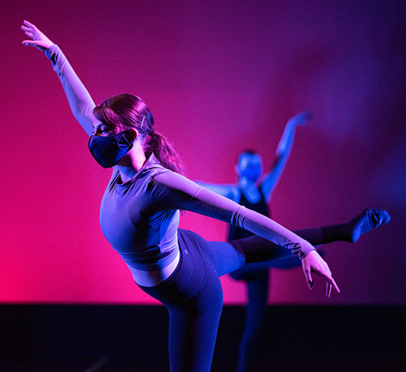 Two dancers pose on stage.