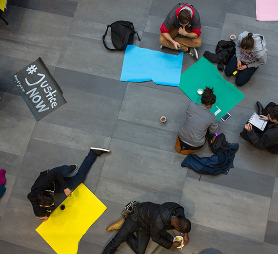 Students make signs for the MLK Rally in the Hemmingson Center Rotunda