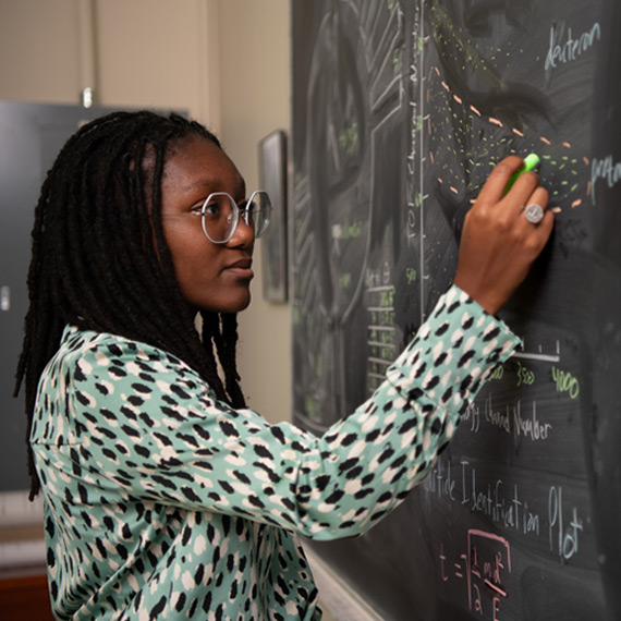 A student works on an equation in Gonzaga's physics lab.