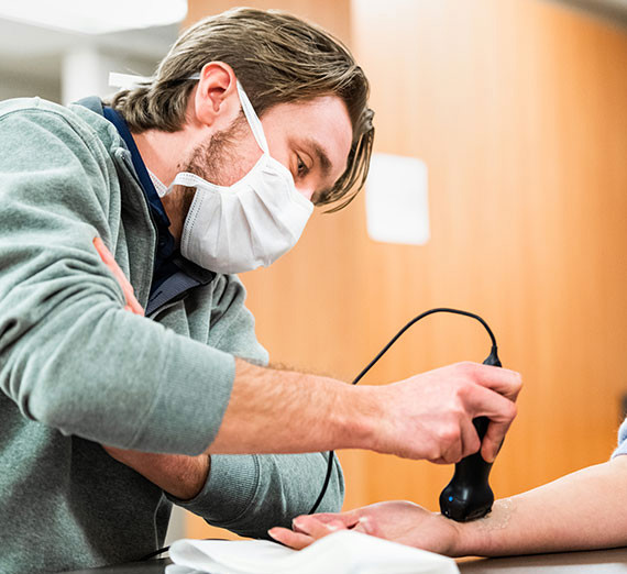 A nurse uses a Butterfly handheld ultrasound device.