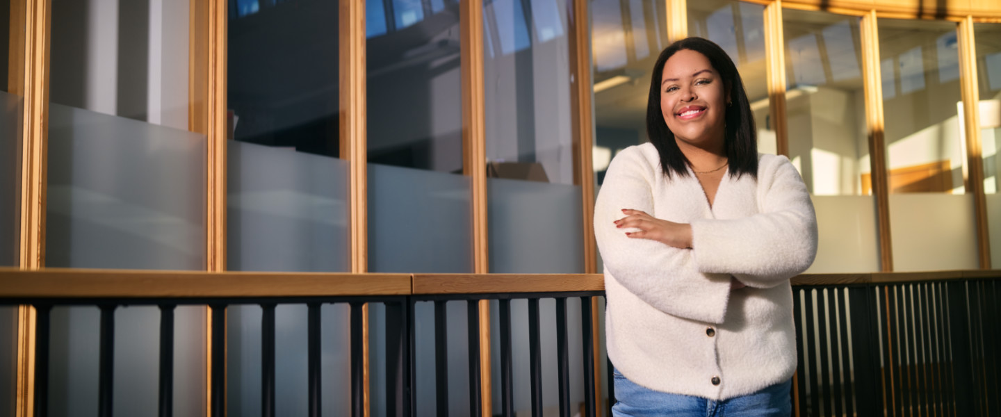 Alyssa Guzman, Gonzaga University Class of 2026, Student Body Association President, Political Science Major, Public Relations and Leadership Studies Minors, stands in Hemmingson Student Union building smiling with her arms crossed wearing a pink sweater and jeans.