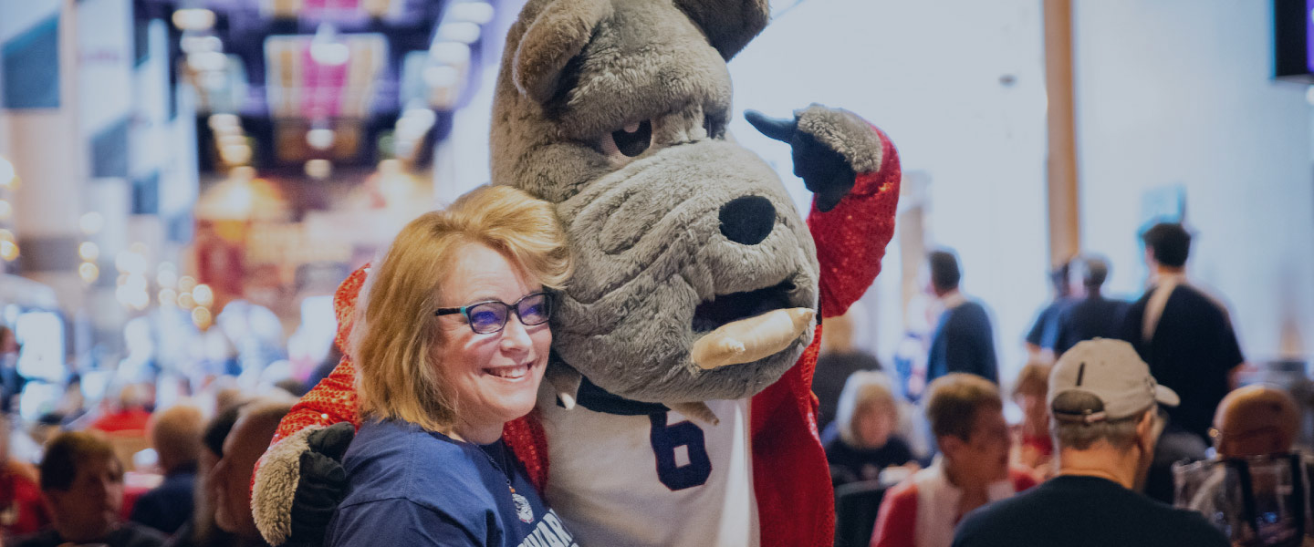 Basketball pregame event attendee poses with Spike, the Gonzaga mascot