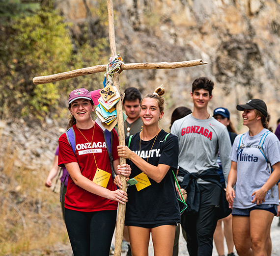 Student biking in the background of a bike wheel's spokes.