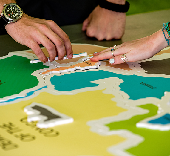 Hands point to a world map.