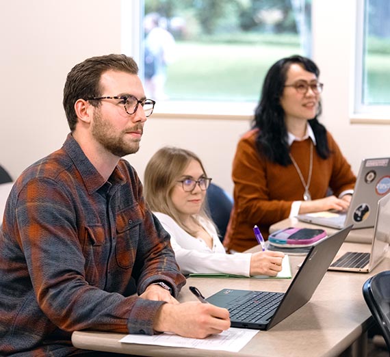 Graduate Accounting Students at Desks Listening to Professor
