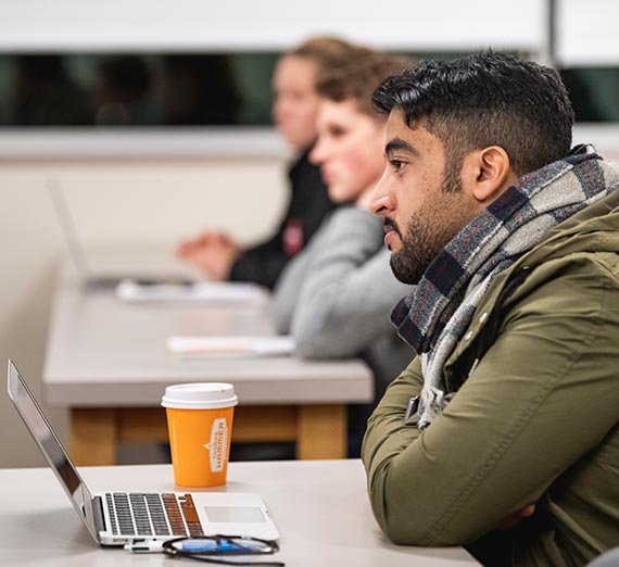 Students at desk listening to instructor