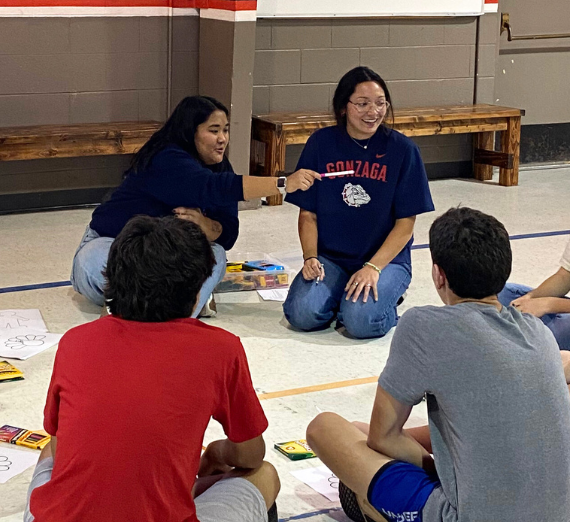School Counseling graduate students interacting with students in a circle 