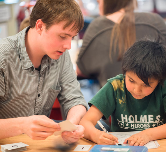 Student tutoring kids in school 