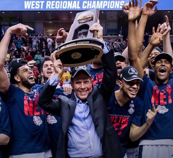 The Gonzaga men's basketball team celebrates their first trip to the Final Four while coach Mark Few holds the West Regional Championship trophy. 