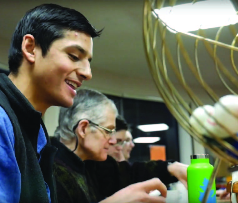 Student volunteer playing Bingo with elderly residents
