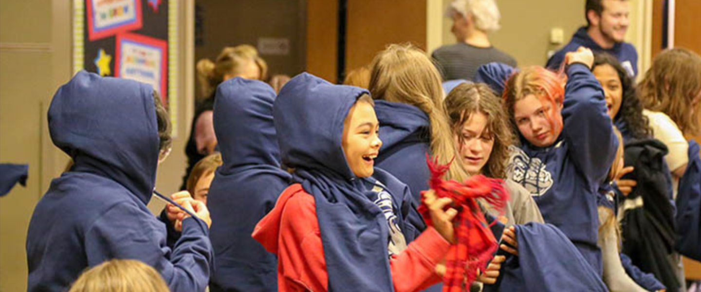 Neighborhood kids putting on GU Hoodies