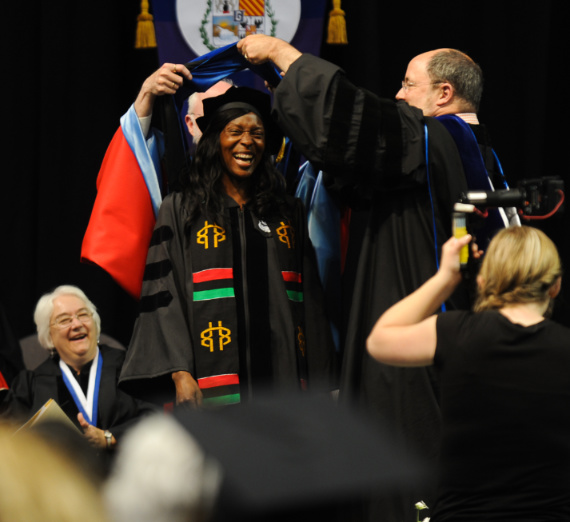 Student having graduation hood placed at commencement 