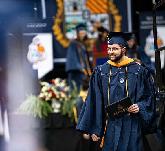 Student walking with diploma.