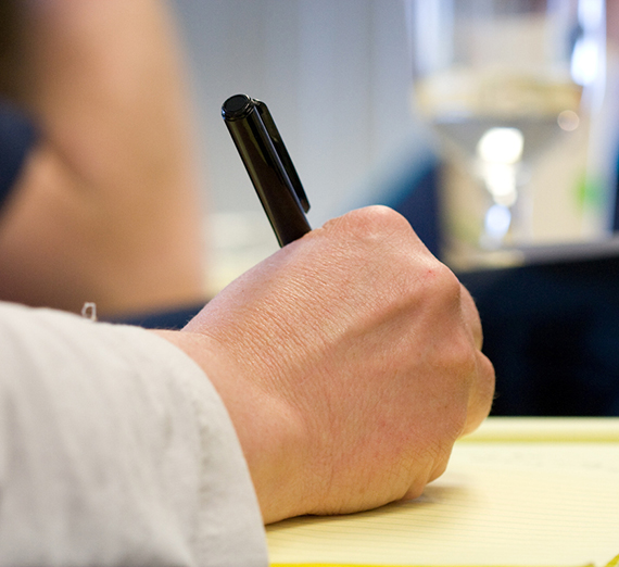 A student writes in thier notebook during class.