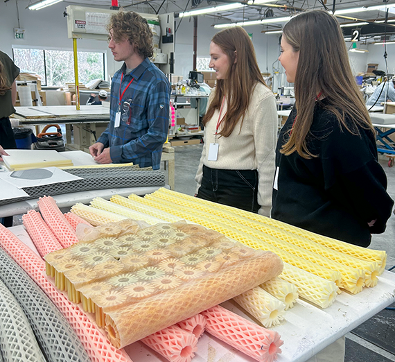 three students with samples of foam padding