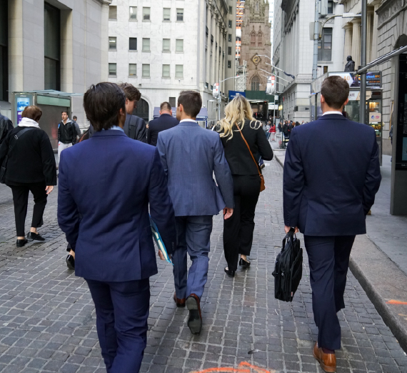 Gonzaga students in business attire walk on cobble street of New York City career trek 