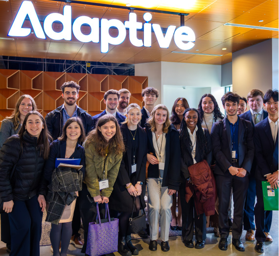 Gonzaga students on the Seattle career trek visit Adaptive, a biotechnologies business, and pose in front of a company sign