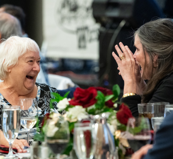 Class of 1974 alumni enthusiastically in conversation at their 50th reunion celebration.  