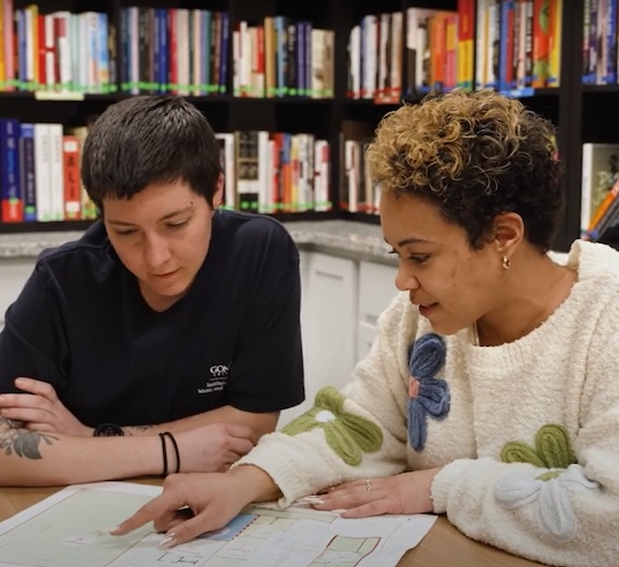 Two people talking over a map