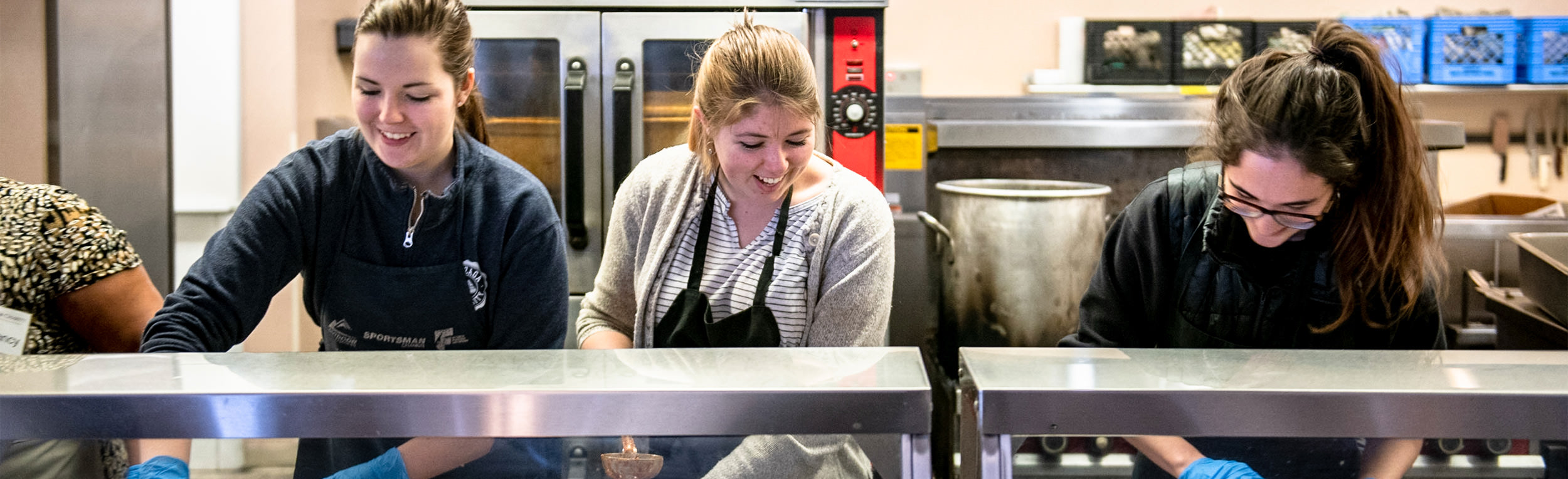 three students serving food