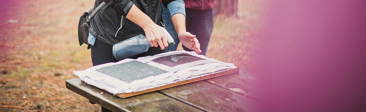 Close up of the hands of an artist working on a creative art project with paper for veterans of war.