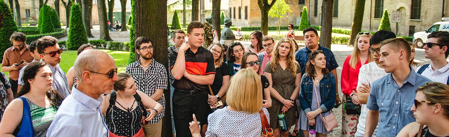 Crowd of people talking with one another outside