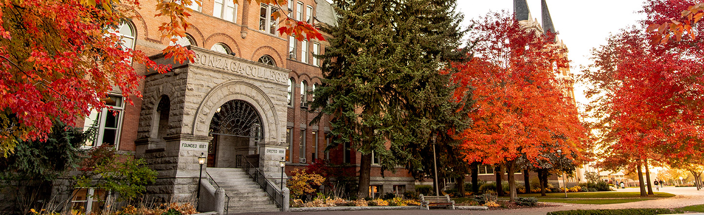Fall foliage frame's Gonzaga's historic College Hall with the spires of St. Aloysius Catholic Church in the background.