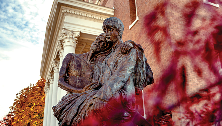 statue of aloysius gonzaga holding infirm person near St Al's church
