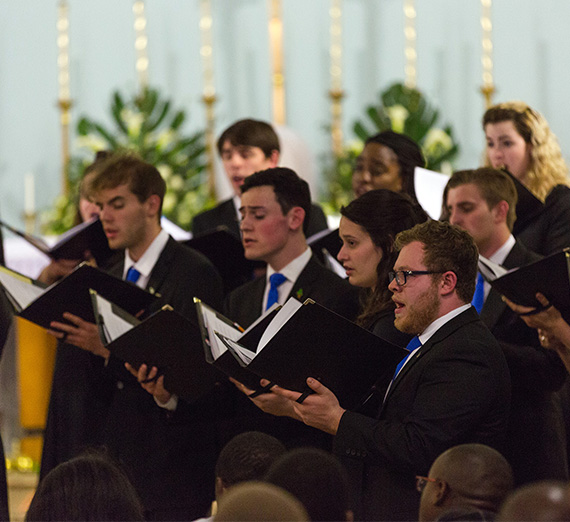 Gonzaga students in concert attire singing to audience in Africa