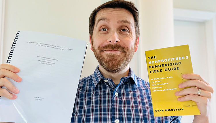 man holding manuscript and printed book