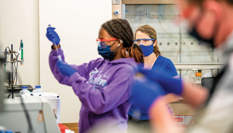 students and faculty demonstrate safe lab procedures while wearing face coverings