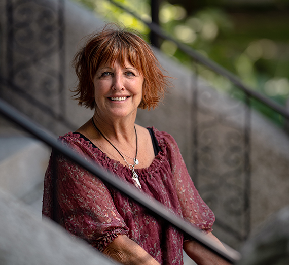 woman with red hair on steps of college hall