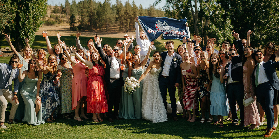 Jacqueline Parker and Brendan Smith wedding surrounded by Zags holding a Gonzaga flag.