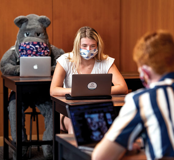 school mascot and two students distanced in a classroom