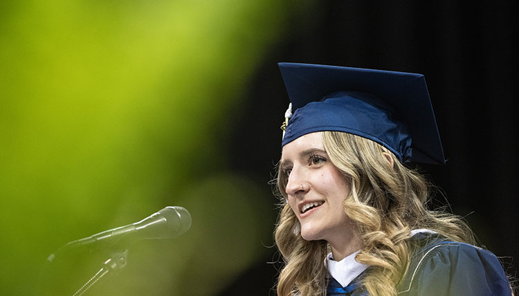 Undergraduate Commencement student speaker Rachel Gotvald speaks into a microphone