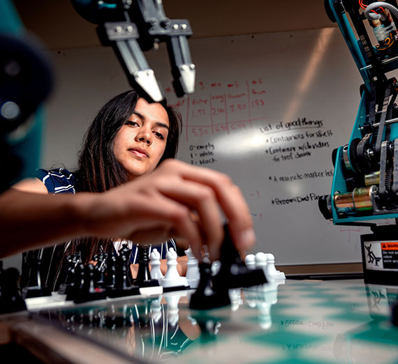 A student plays chess against a robot