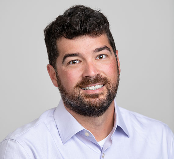 Economics professor Ryan Herzog smiles at the camera