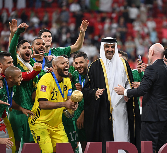 Players celebrate a soccer victory with a trophy